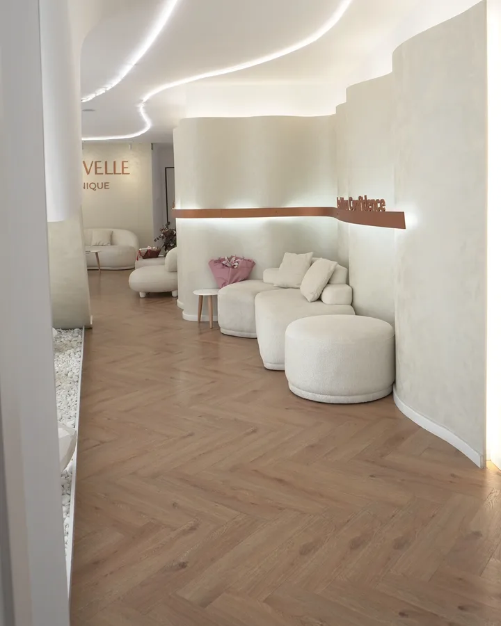 Area lounge pazienti di Nouvelle Clinique con divani e illuminazione LED