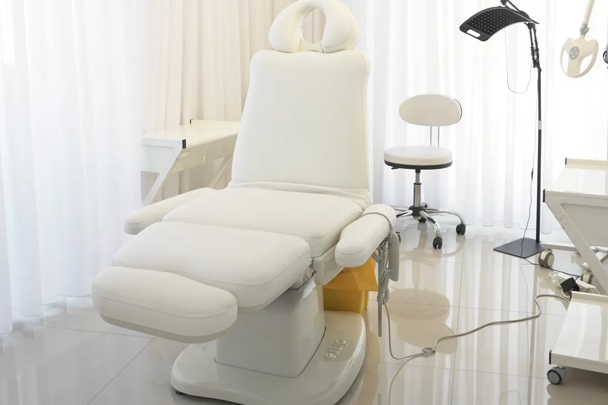 Sala procedure di Nouvelle Clinique a Tirana, clinica partner per il trapianto di capelli — poltrona medicale e lampada d'ingrandimento
