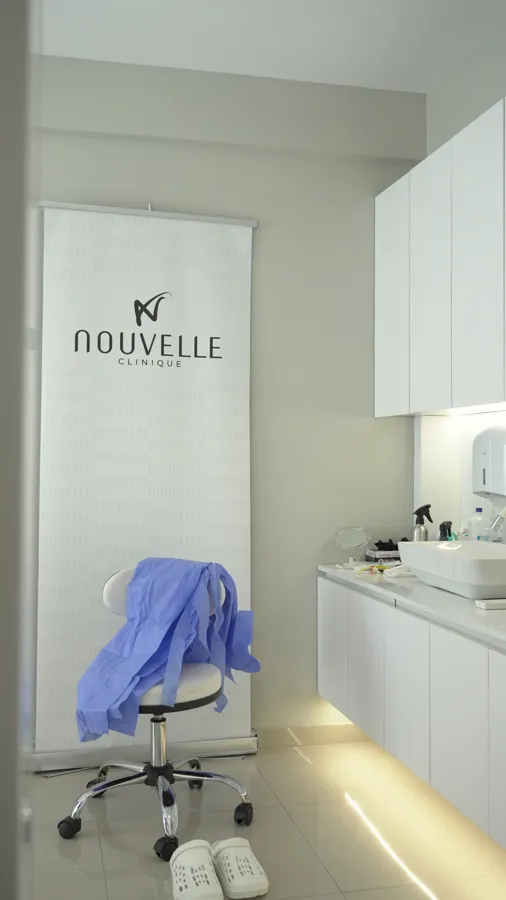 Sala trattamento con logo Nouvelle Clinique e poltrona medicale