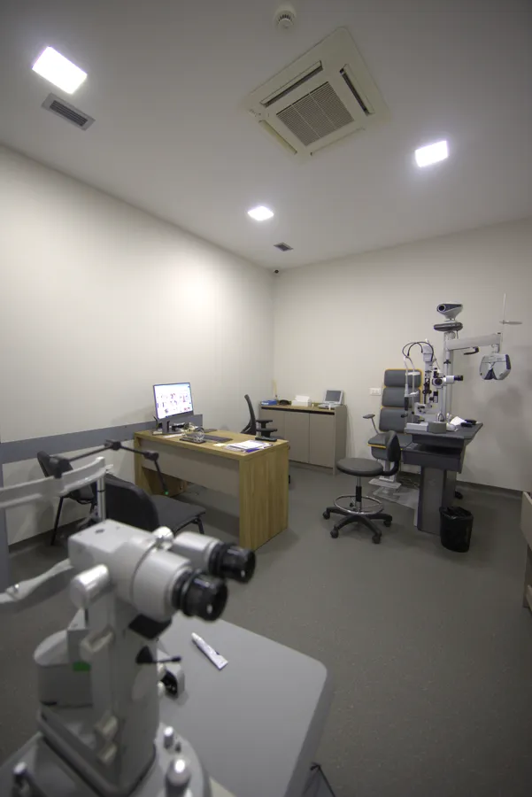 Sala visita oculistica con poltrona, strumenti e monitor di anatomia dell'occhio
